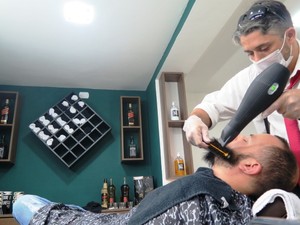 Barbeiro faz 'chapinha' em barba de cliente  (Foto: Orion Pires / G1)