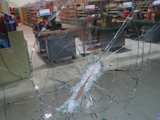 Marcas dos tiros ficaram nos vidros no supermercado  (Foto: Luiz Fernando/ Jornal Acontece )