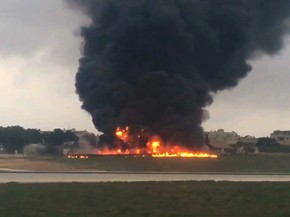 Avião de pequeno porte caiu em aeroporto da Malta nesta segunda-feira (24). A aeronave pegou fogo (Foto: Ed De Gaetano/ AP )