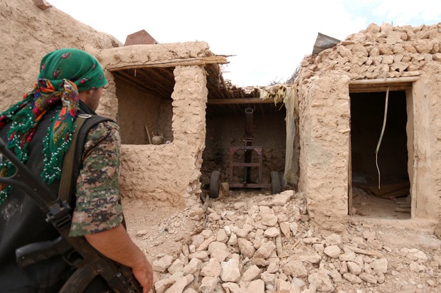 Membro das Forças Democráticas Síria inspeciona área que era ocupada por militantes do Estado Islâmico, em região rural no sul de Manbij (Foto: Rodi Said/Reuters)