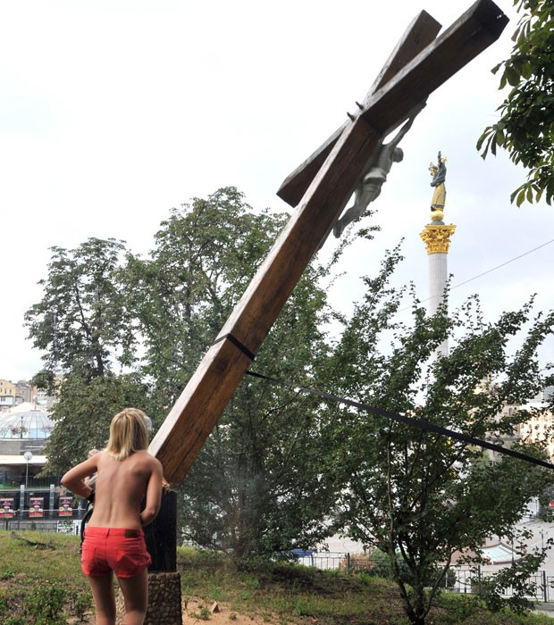 Integrante do grupo Femen corta cruz ortodoxa (Foto: AFP)