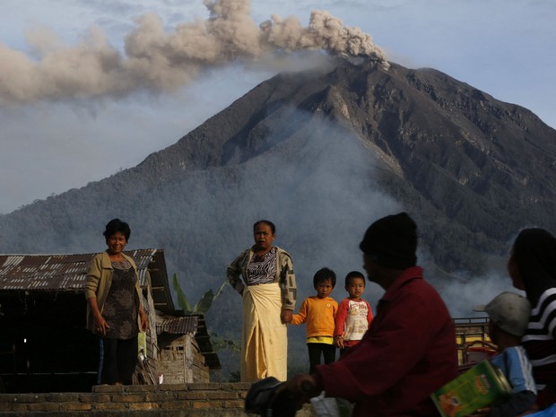 Família deixa casa para abrigo temporário, enquanto o Monte Sinabung expele cinzas no distrito de Karo, no norte de Sumatra, na Indonésia. (Foto: Beawiharta/Reuters)