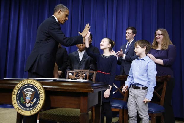 O presidente dos EUA, Barack Obama, dá um 'high five' em menina que escreveu a ele pedindo mais controle de armas nos EUA, nesta quarta-feira (16), durante ato na Casa Branca (Foto: Reuters)