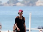Grávida, Flávia Sampaio caminha na orla de praia carioca