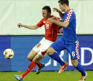 Jogadores das seleções da Suíça e Croácia disputam bola em amistoso internacional (Foto: Walter Bieri/AP)
