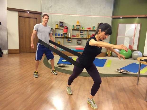 A terapeuta ensinou mais um exercício, feito com um elástico, que ajuda a trabalhar a força (Foto: Mariana Palma/G1)