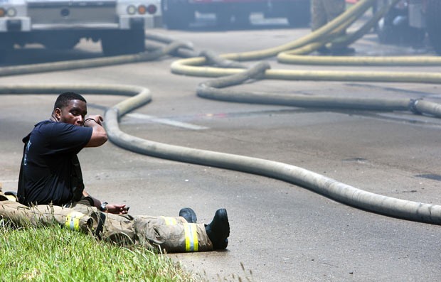 Bombeiro toma fôlego durante combate ao incêndio (Foto: AP Photo/Houston Chronicle, Cody Duff)