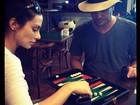 Cleo Pires e Rodrigo Lombardi jogam gamão em aeroporto