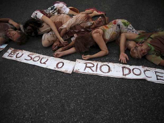Manifestantes se deitam ao lado de com cartazes com a frase "Eu sou o rio Doce" durante protesto no Rio de Janeiro. Nesta segunda (30) começa COP 21, a Conferência da ONU sobre Mudanças Climáticas em Paris. (Foto: Pilar Olivares/Reuters)