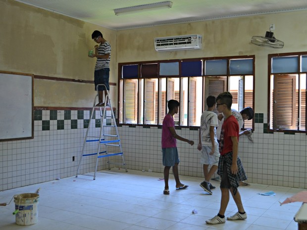 Alunos pintam parede de sala de aula durante mutirão realizado neste sábado (Foto: Aline Nascimento/G1)