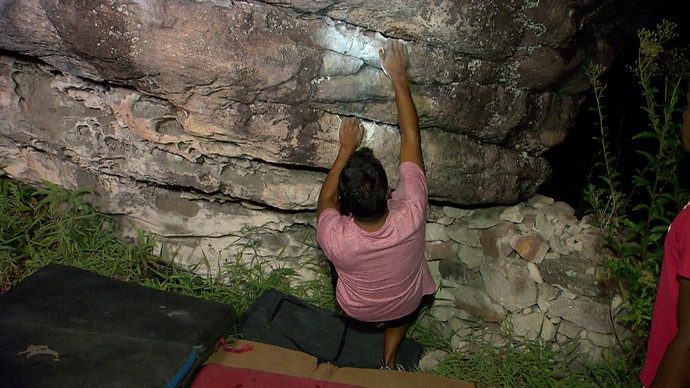 Repórter Pablos Vasconcelos escala pedra usando a técnica do boulder (Foto: TV Bahia)