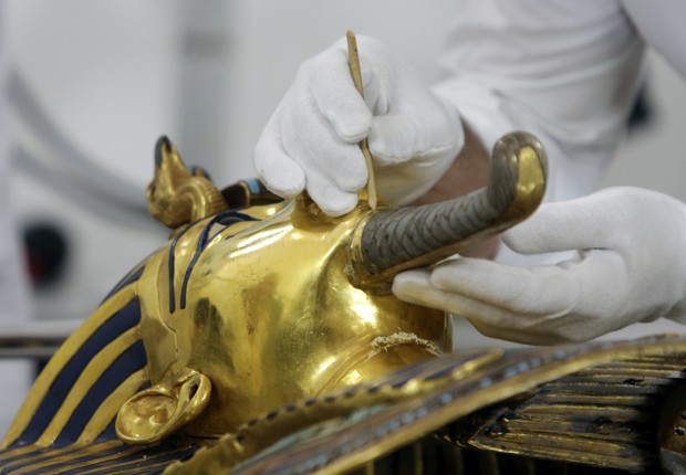 Restaurador Christian Eckmann examina barba da máscara mortuária de Tutancâmon nesta terça-feira; barba foi colada com massa de epóxi  (Foto: AP Photo/Amr Nabil)