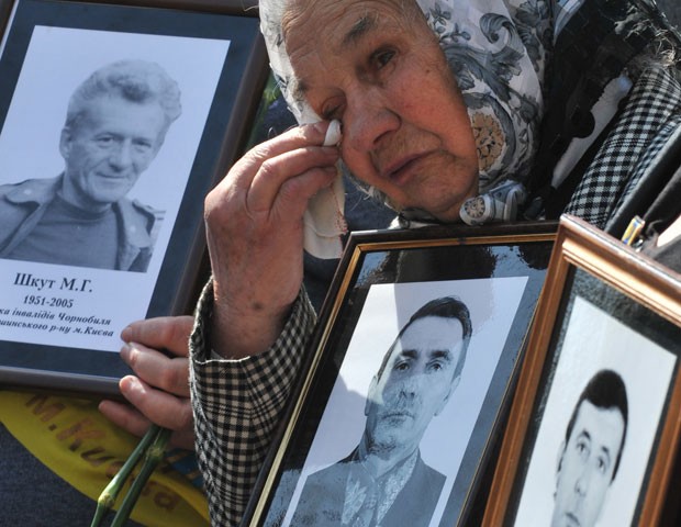 ViÃºva mostra foto de seu marido, morto no acidente nuclear de Chernobyl, durante ato em memÃ³ria Ã s vÃ­timas em Kiev nesta quinta-feira (26) (Foto: Sergei Supinsky/AFP)