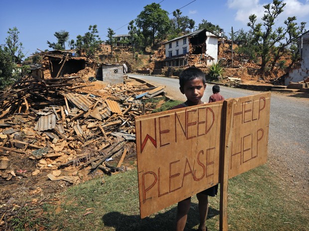 Criança pede ajuda em área devastada por terremoto no Nepal (Foto: AP/ Manish Swarup)