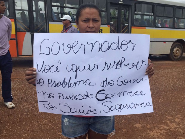 Manicure Rose Silva, moradora da região sob risco de derrubada, com cartaz de protesto contra o GDF (Foto: Jéssica Nascimento/G1)