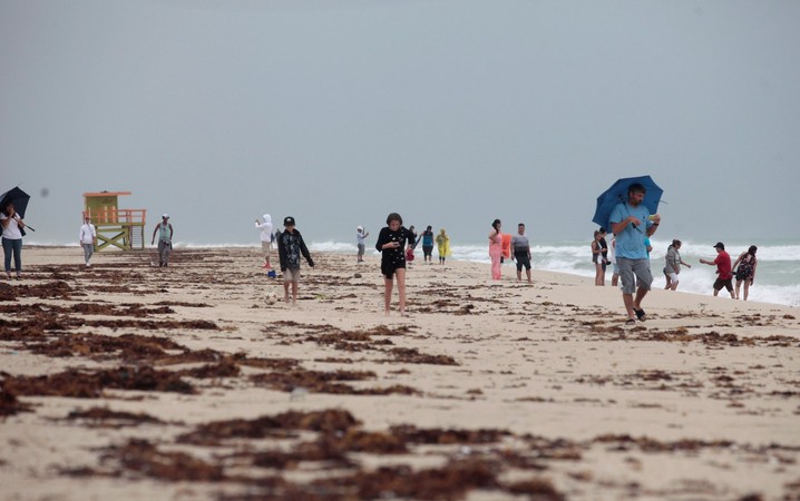 Pessoas caminham pela praia em Miami Beach, nos EUA, antes da chegada do furacão Matthew