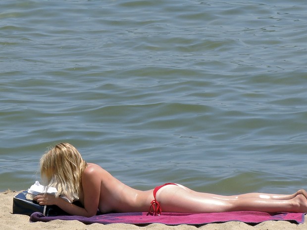 Mulher aproveita as altas temperaturas nesta terça (26) em Barcelona na praia Barceloneta. (Foto: Manu Fernandez/AP)