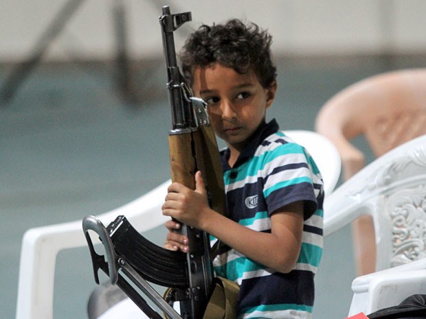 Crianças comemoravam com rifle nas mãos (Foto: Mohamed al-Sayaghi/Reuters)