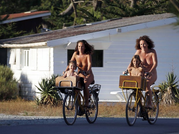 As suíças Karel e Celine andam de bicicleta com suas filhas no camping (Foto: Regis Duvignau/Reuters)