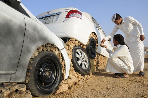 Jovens montam seus carros em pedras na cidade saudita de Duba  (Foto: Mohamed Al Hwaity/Reuters)
