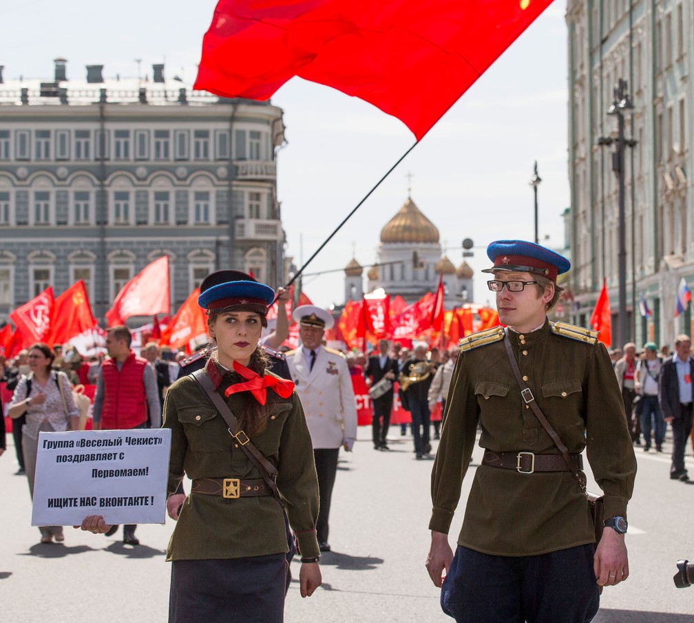 Participante de marcha do Dia do Trabalhador em Moscou usam uniforme da NKVD, nome da polícia secreta soviética entre 1934 e 1946, ao participar de marcha organizada por comunistas nesta segunda-feira, dia 1º de maio de 2017; a exemplo da época soviética, eles desfilaram com bandeiras vermelhas com o símbolo do martelo e da foice (Foto: Alexander Zemlianichenko/AP)