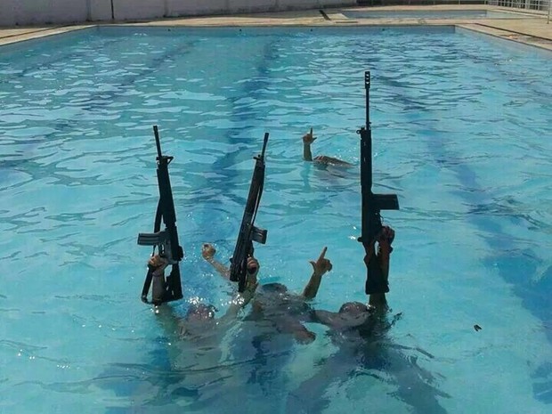 Bandidos do Complexo da Pedreira ostentam fuzis dentro de piscina na Vila Olímpica de Honório Gurgel.  (Foto: Divulgação/Jornal Extra)