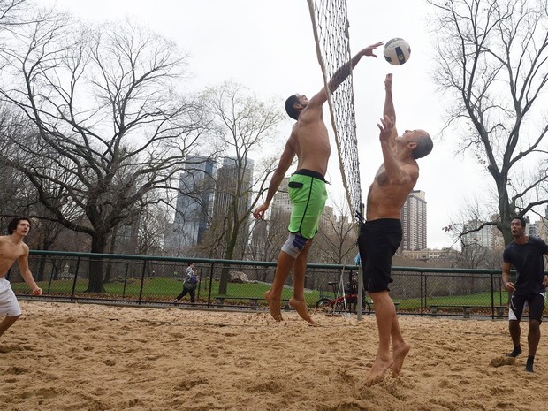 Grupo joga vôlei no Central Park, em Nova York, na quinta (24). A véspera de Natal deste ano é a mais quente já registrada na cidade (Foto: AFP Photo/Don Emmert)
