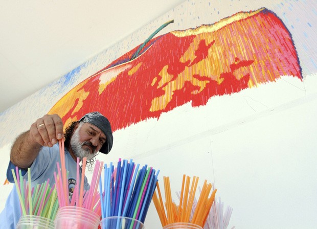 Artista pretende usar mais de 180 mil canudos para compor imagem de maçã mordida (Foto: Arben Celi/Reuters)