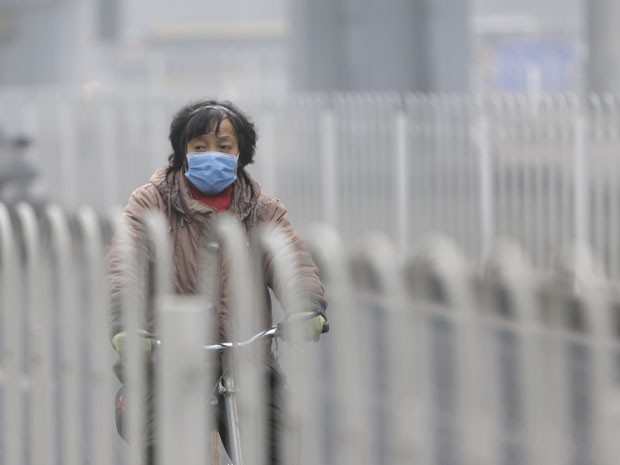 Chinesa caminha nesta terça-feira (29) com máscara para proteger da poluição em Pequim, na China (Foto: China Daily/Reuters)