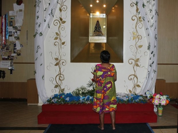 Devota descalça reza diante da imagem de Nossa Senhora Aparecida (Foto: Ivanete Damasceno/G1)