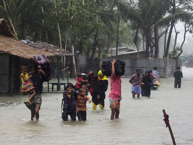 Moradores têm de deixar suas casas após passagem do ciclone neste sábado (21). (Foto: AFP)