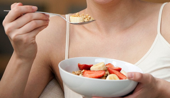 Mulher comendo salada de frutas (Foto: Getty Images) Mulher comendo salada de frutas (Foto: Getty Images)