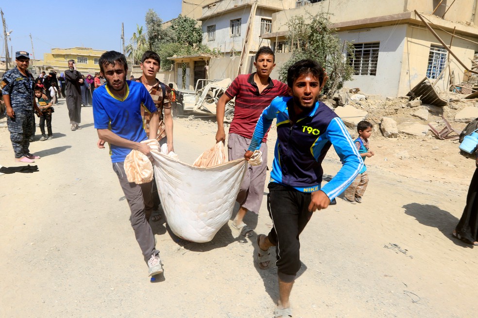 Meninos carregam ferido durante fuga de civis em Mossul, no Iraque (Foto: REUTERS/Alaa Al-Marjani)