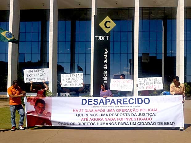 Familiares do homem desaparecido após suposta ação policial exibem faixas e cartazes pedindo investigação do caso (Foto: Gabriella Julie/G1)
