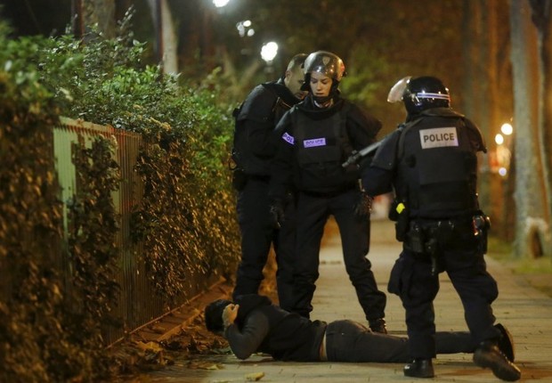 Policiais checam a identidade de um homem próximo ao Bataclan, em Paris, onde uma ação coordenada provocou tiroteios e explosões (Foto: Christian Hartmann/Reuters)