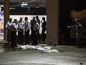 Polícia israelense ao lado de corpo de palestino após ataque a estação em Beersheba (Foto: Tsafrir Abayov/AP) Polícia israelense ao lado de corpo de palestino após ataque a estação em Beersheba (Foto: Tsafrir Abayov/AP)