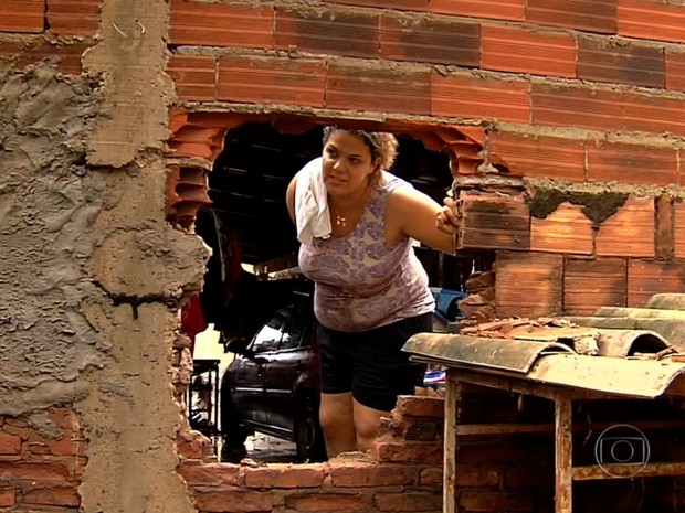 Buraco no muro foi utilizado para retirar filhas de casa inundada em Goinia, em Gois (Foto: Reproduo/TV Globo)