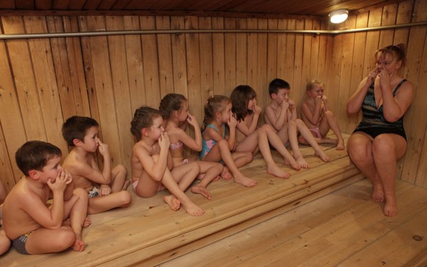 A técnica de fitness Margarita Filimonova instrui as crianças na sauna antes da saída para o banho gelado no jardim de infância russo (Foto: Ilya Naymushin/Reuters)