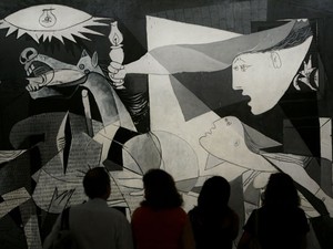 Visitantes observam em museu de Madri a famosa obra de Pablo Picasso que representou o bombardeio em Guernica (Foto: Bernat Armangue/AP)