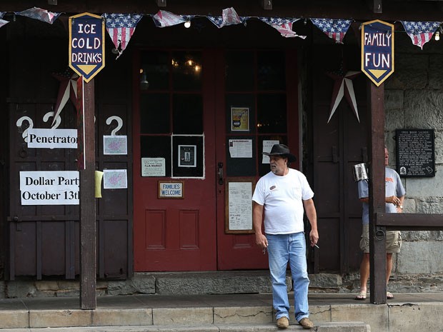 Morador na porta do 'Iron Door Saloon', em Groveland, Califórnia (Foto:  Justin Sullivan/Getty Images/AFP)