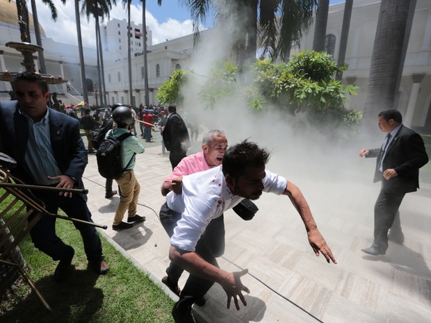  Deputado da oposição Amando Armas e funcionários do Parlamento da Venezuela correm de apoiadores de Maduro em Caracas