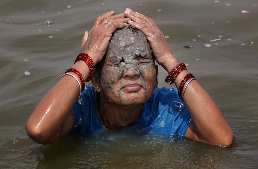 Indiana toma banho de lama no rio Ganges para se refrescar do calor em Allahabad, na Índia. Em algumas regiões do país, as temperaturas chegaram a 45°C