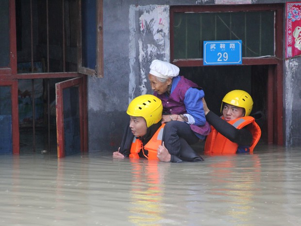 Equipes de resgate salvam um morador de um prédio inundado em Chongqing, na China (Foto: Reuters)