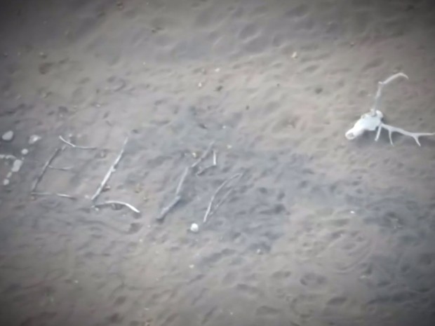 Americana pediu ajuda escrevendo a palavra help (ajuda) com gravetos e pedras deixados na areia (Foto: BBC)
