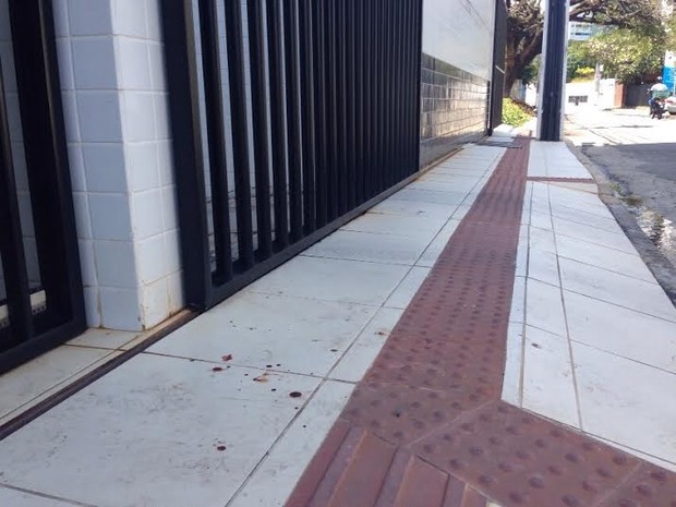 Calçada do prédio onde vivia o casal está com manchas de sangue (Foto: Natália Souza/G1)