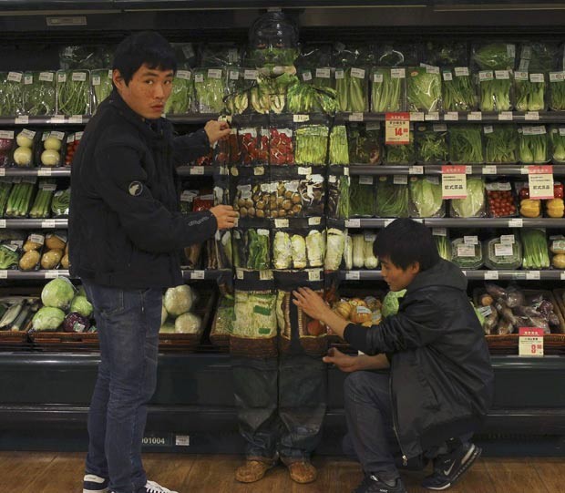 Liu Bolin exibe camuflagem diante de uma gôndola de legumes e vegetais de um supermercado em Pequim, na China, em novembro de 2011 (Foto: China Daily/Reuters)