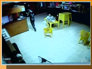 Imagem mostra momento em que assaltante aborda funcionário de bar, na avenida Palmas Brasil (Foto: Reprodução/TV Anhanguera)