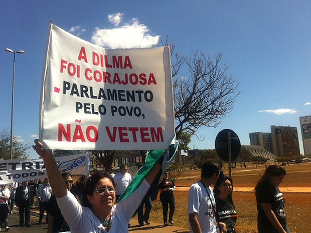 Participante de marcha levanta cartaz com frase de apoio aos vetos da presidente Dilma ao Ato Médico (Foto: Isabella Formiga/G1)