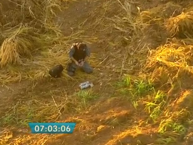 Policial do Gate leva material explosivo apreendido para ser detonado em um terreno baldio em Santo André (Foto: TV Globo/Reprodução)