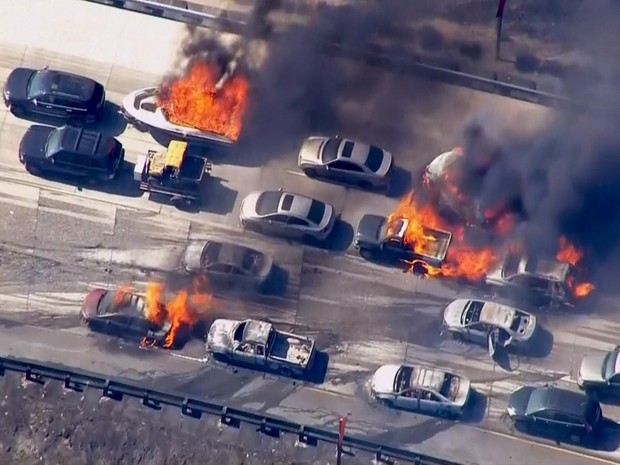 Frame retirado de vídeo mostra carros em chamas na rodovia Interstate 15 na passagem de Cajon, na Califórnia. Um incêndio florestal invadiu a auto-estrada e incendiou vários carros e caminhões (Foto: NBCLA.COM/Reuters)